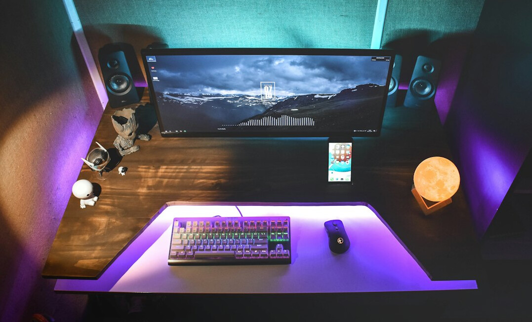 Overhead view of a colour grading desk with control surface and monitor